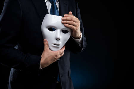 Masked businessman trouble and suffering. dark background.の写真素材