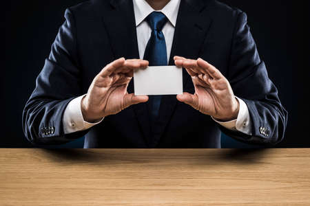 Businessman with business card, holding in hand.の写真素材
