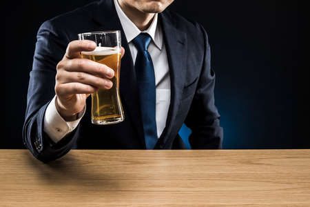 Businessman drinking beer at bar counter.の写真素材