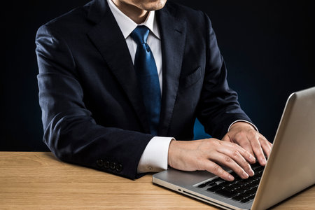 Businessman open the laptop, on wooden table.の写真素材