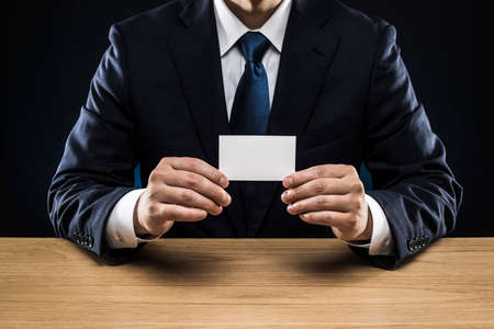 Businessman with business card, holding in hand.の写真素材