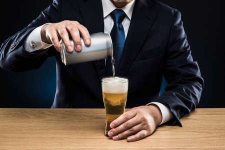 Businessman drinking beer at bar counter.の写真素材