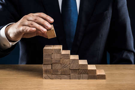 Businessmen stacked up wooden blocks.の写真素材