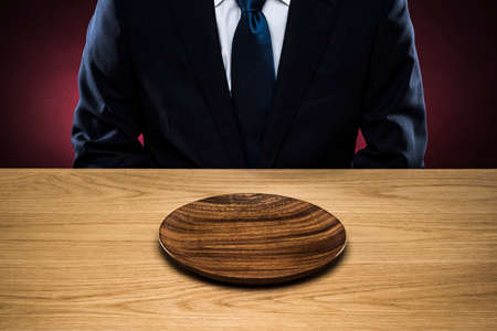 Businessman eats. plate on wooden table.の写真素材