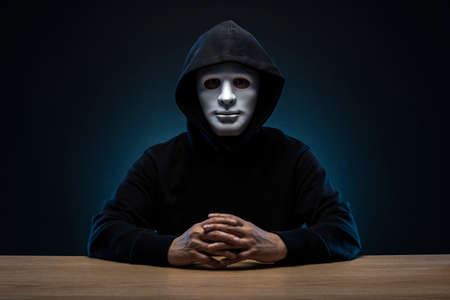 Masked man in hoodie. Dark background.の写真素材