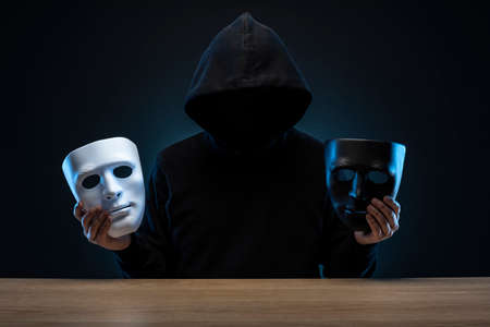 Masked man in hoodie. Dark background.の写真素材