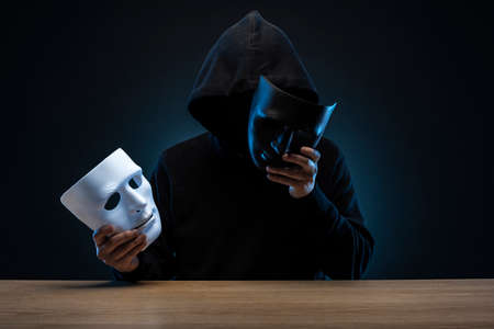Masked man in hoodie. Dark background.の写真素材