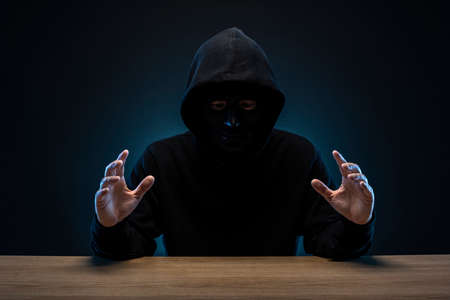Masked man in hoodie. Dark background.の写真素材