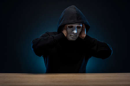 Masked man in hoodie. Dark background.の写真素材