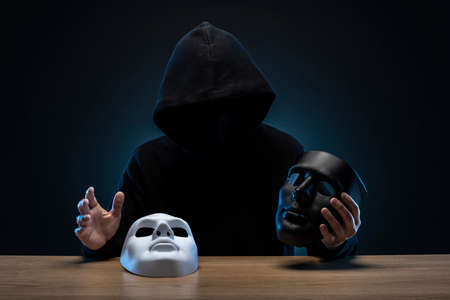 Masked man in hoodie. Dark background.の写真素材