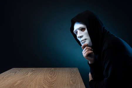 Masked man in hoodie. Dark background.の写真素材