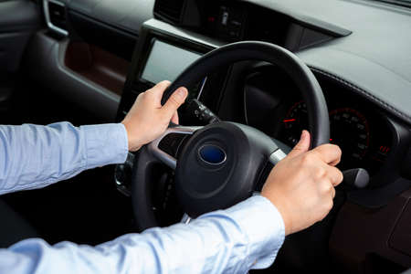 Man driving a car. Hand close-up.