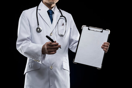 Doctor in lab coat on black background.の写真素材