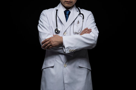 Doctor in lab coat on black background.の写真素材