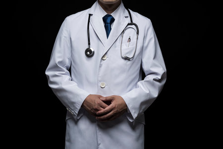 Doctor in lab coat on black background.の写真素材