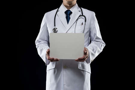 Doctor in lab coat on black background.の写真素材