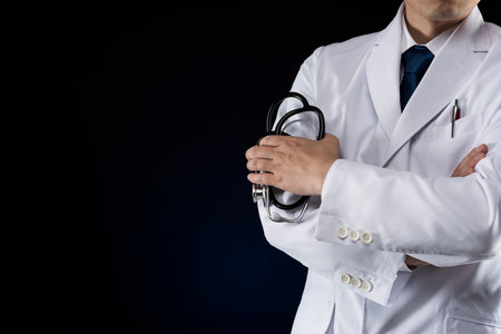 Doctor in lab coat on black background.の写真素材