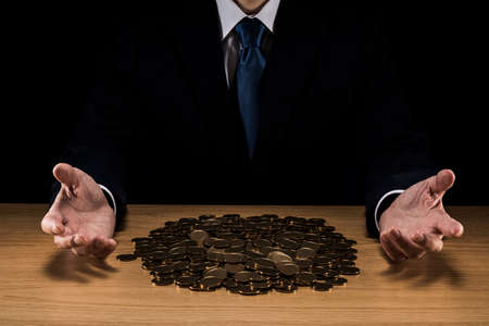 Man holding a pile of coins.の写真素材