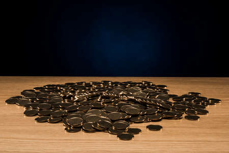 Stacked coins on wooden desk.の写真素材