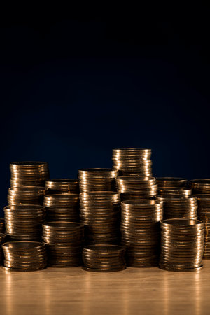 Stacked coins on wooden desk.の写真素材