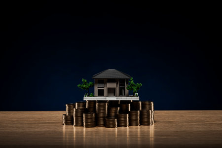Pile of coins and house model.の写真素材