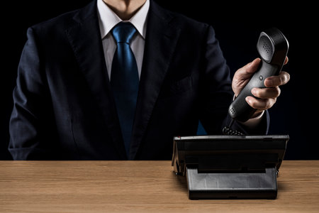 Businessman with business phone on desk.の写真素材