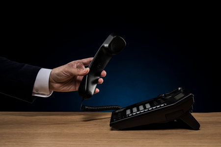 Businessman with business phone on desk.
