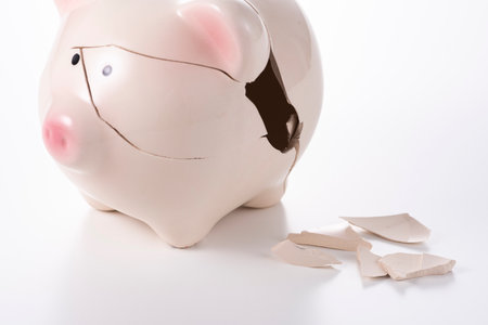Cracked piggy bank on white background.の写真素材