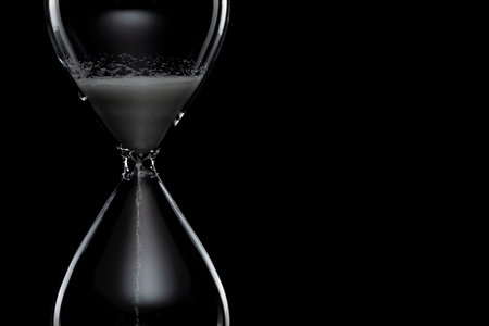 Close up of hourglass on black background.の写真素材