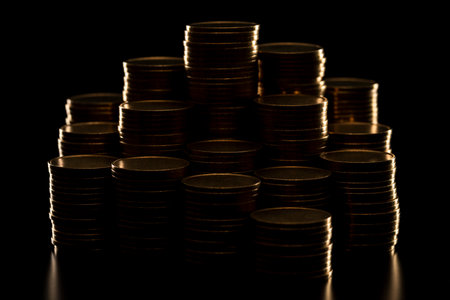 Pile of coins stacked on black background.