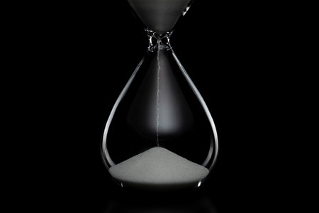 Close up of hourglass on black background.