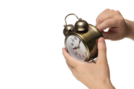 Holding alarm clock in hand isolated white.