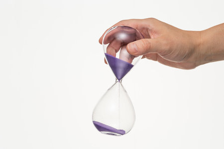 Male hand with hourglass on white background.