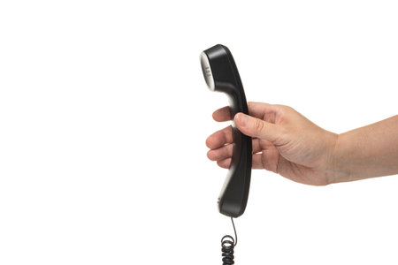 Male hand holding a handset on white background.の写真素材