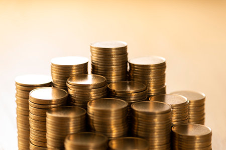 Pile of coins on a wooden desk.