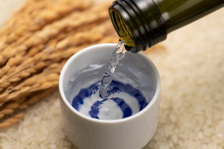 Cold sake with rice and ear of rice  on the tableの写真素材