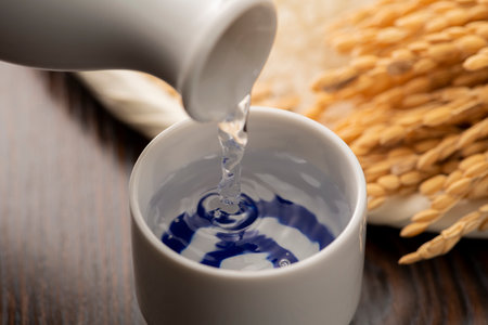 Cold sake with rice and ear of rice  on the tableの写真素材
