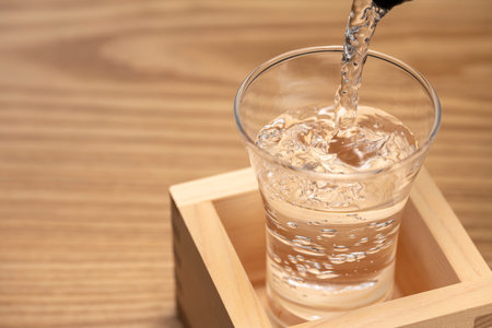 Sake overflows from the square cupの写真素材