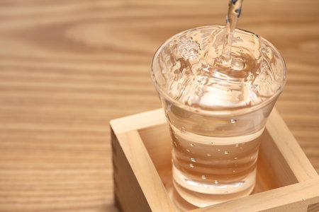 Sake overflows from the square cupの写真素材