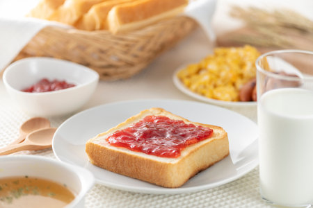 Bread and strawberry jam on the breakfast tableの写真素材