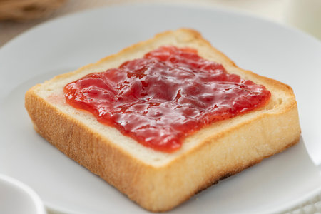 Spread strawberry jum on toasted breadの写真素材