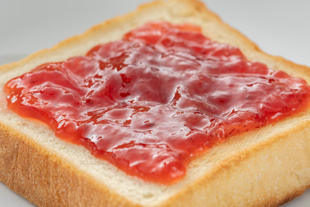 Spread strawberry jum on toasted breadの写真素材