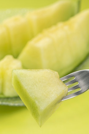 Eat the cut green melon with a forkの写真素材