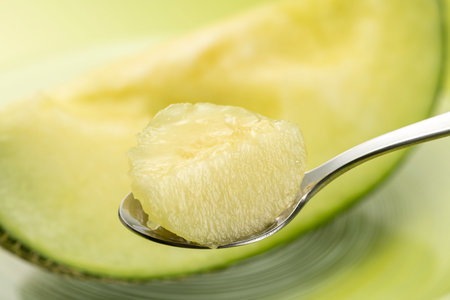 Eat the cut green melon with a spoonの写真素材