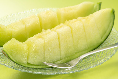 Eat the cut green melon with a forkの写真素材