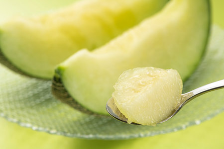 Eat the cut green melon with a spoonの写真素材