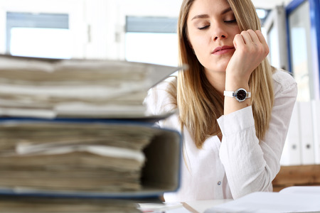 Lot of work wait for tired and exhausted woman. Huge pile of document folders, headache and depression, irs, new problems, emotion expression, vacancy or holiday dream conceptの写真素材