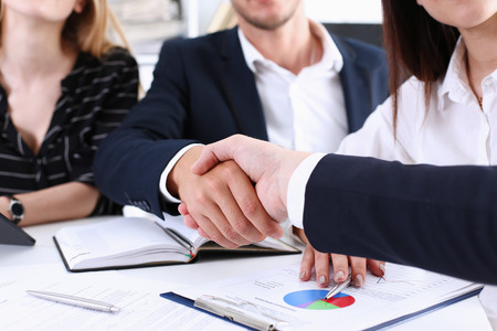 Greup business people shake hands as hello in office closeup. Friend welcome, introduction, greet or thanks gesture, product advertisement, partnership approval, arm, strike a bargain on deal conceptの写真素材