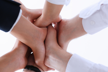 Group of people in suits crossed hands in pile for win closeup. White collar leadership, high five, cooperation initiative achievement, corporate life style, friendship deal, heap, stack conceptの写真素材