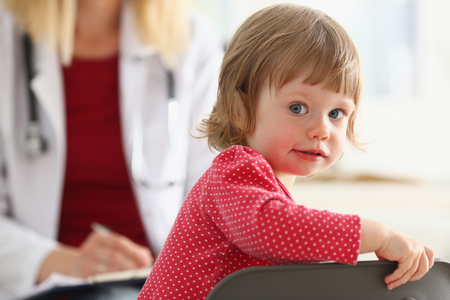 Little child with mother at pediatrician reception. Physical exam, cute infant portrait, baby aid, healthy lifestyle, ward round, child sickness, clinic test, high quality and trust conceptの写真素材